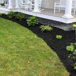 Landscaping along lawn and house by Tammaro Landscaping
